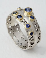 'Pierced Ring' in 18K white gold with small blue Sapphires
